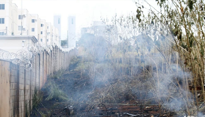 Área de incêndio que lambeu muro de condomínio ainda queima no Jd. Seminário